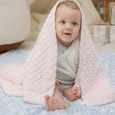 Bébé assis avec couverture bébé sur sa tête