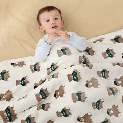 Bébé couché avec COUVERTURE POUR BEBE EN LAINE-motif ourson 