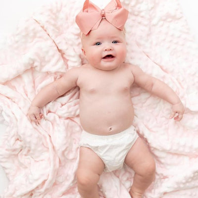Bébé fille boucle rose autour tête couchée sur couverture bébé