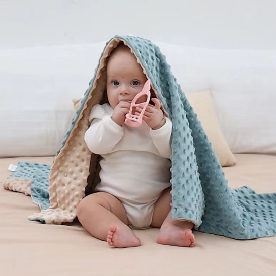 Couverture bébé sur tête de bébé assis