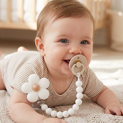 attache tétine sur bébé avec tétine dans sa bouche