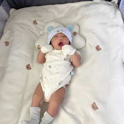 Bébé couché sur COUVERTURE EN LAINE POUR BEBE