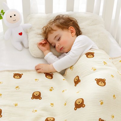Bébé dort couché sur côté avec sa couverture bébé ourson