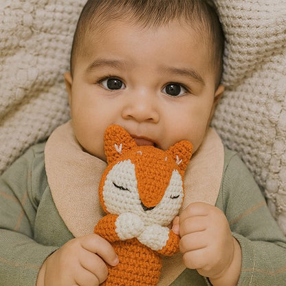 Bébé garçon couché qui serre doudou renard 