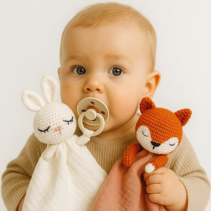 Bébé qui serre deux doudou lapin et renard